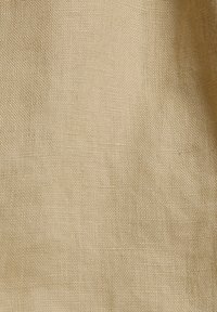 Tissu tissé beige avec une surface unie et texturée montrant des fibres naturelles et un motif de tissage légèrement grossier.