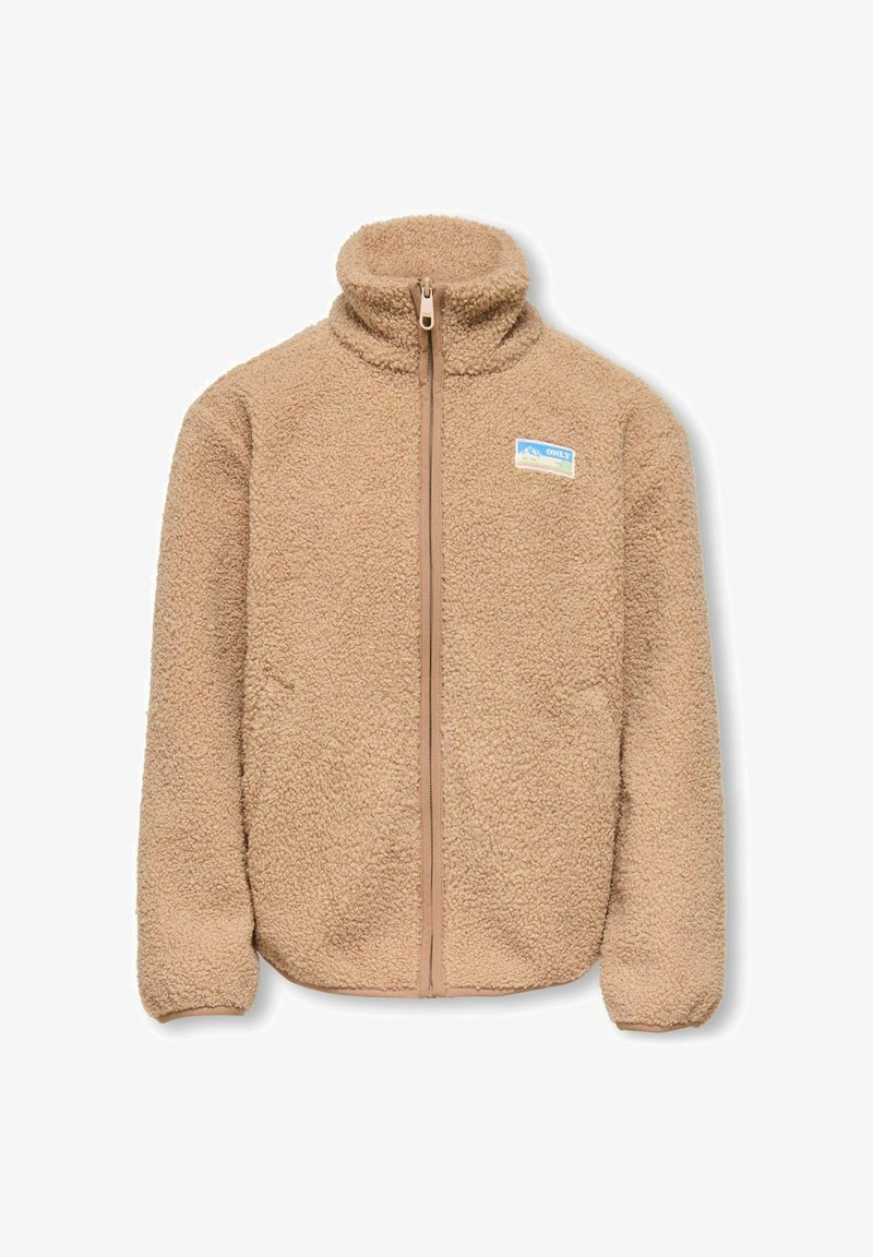 Giacca in pile beige con collo alto e chiusura con cerniera. Presenta una piccola toppa logo blu e gialla sul lato sinistro del petto. Texture morbida.