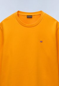 Felpa in cotone giallo brillante con collo a girocollo a costine e piccolo dettaglio della bandiera norvegese ricamata sul lato sinistro del petto.