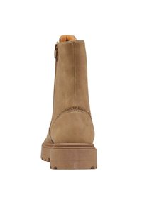 Stivale alla caviglia in suede beige con suola in gomma spessa, zip laterale e cucitura accentuata curvata sul tallone. Texture liscia con dettagli minimi.