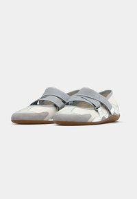 Γκρι και λευκά παπούτσια χωρίς κορδόνια με λαστιχένια σόλα, που διαθέτουν σχέδιο με λουράκι που διασταυρώνεται και απαλές σουέντ λεπτομέρειες στα δάχτυλα και στις πλευρικές πλευρές.