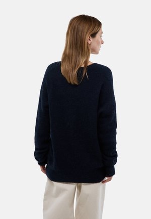 Pull en laine oversize bleu marine fabriqué à partir d'un matériau doux et pelucheux, avec un col rond, des manches longues et des poignets et un ourlet côtelés.