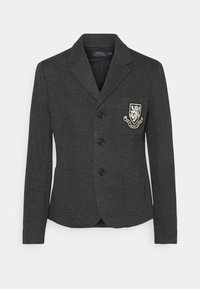 Kolkgrå blazer i stickad offert med två framfickor och en knäppning med en knapp. Har en dekorativ broderad skyltdocka.