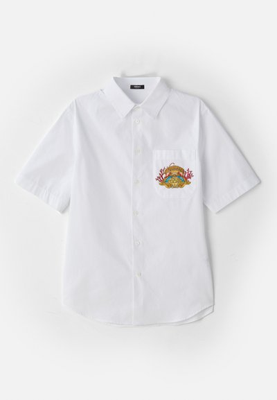 Baltas īsām piedurknēm pogājams krekls ar apkakli, piedāvā krāsainu izšūtu dizainu uz kreisā krūšu kabatas.