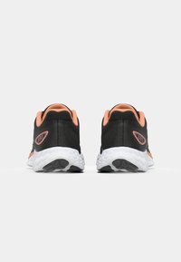Black athletic shoes with orange accents, mesh upper, padded collar, and patterned white sole. Features a logo on the heel and textured fabric.