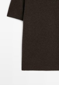 Brun stickad tröja med en mjuk textur, korta ärmar och en avslappnad passform. Enkelt mönster, inga mönster eller dekorationer.