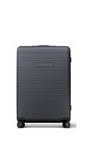 Dark gray hard-shell suitcase with horizontal ridges, a top handle, and four black spinner wheels on a white background.