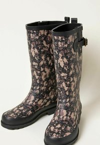 Patterned waterproof rain boots with a glossy finish. Colors include black, beige, and mauve. Features a buckle detail and rugged soles.