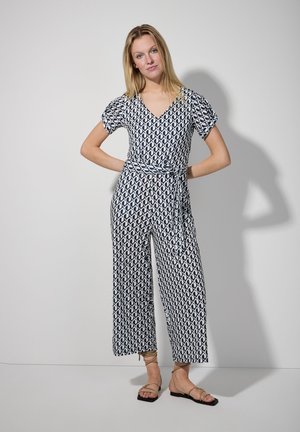 Marineblaues und weißes gemustertes Jumpsuit mit V-Ausschnitt, kurzen Puffärmeln und taillierter Taille. Mit weitem Bein.