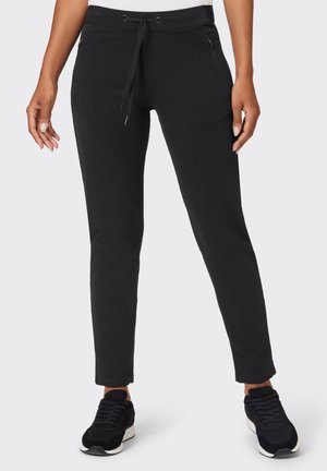 Black jogger pants with a drawstring waist, slim fit, side pockets, and a smooth texture. Paired with black sneakers for a casual look.
