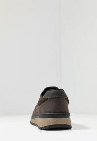 Braune Lederschuhe mit einer strukturierten beigen Sohle, schwarzen Akzenten und kontrastierenden Nähten. Mit niedrigem Schuhkragen und abgerundetem Design.