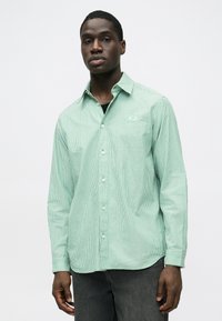 Cămașă cu nasturi în dungi verzi, guler, mâneci lungi și detaliu cu logo pe partea stângă, realizată dintr-un material ușor.
