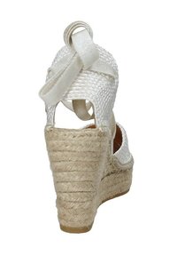 Sandalo con zeppa in espadrilles intrecciato bianco, con tacco testurizzato, cinture in tessuto e base in juta intrecciata. La vista posteriore mette in evidenza l'altezza del tacco.