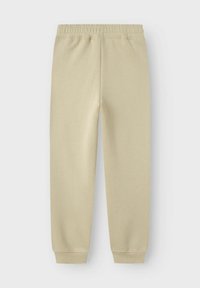 Beiga sweatpants i ett mjukt tyg, med elastisk midja, smalnande manschetter och en slät yta, lämpliga för vardagsbruk.