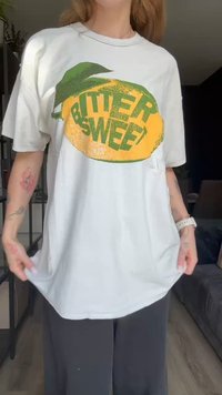 Camiseta de algodón blanca con un gráfico de limón y el texto "BITTER SWEET" en verde y amarillo, de corte holgado con mangas cortas.