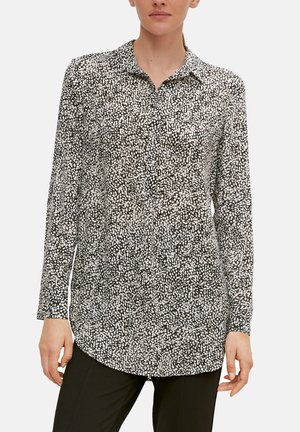 Black and white patterned long-sleeve shirt with a collar, featuring abstract speckled design. Soft fabric with a relaxed fit, curved hem.