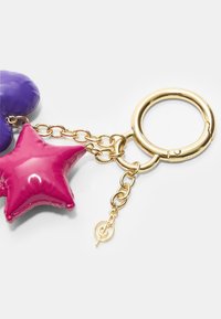 Accessoire porte-clés en métal avec une étoile rose brillante et une forme violette, reliées par une chaîne dorée avec un fermoir rond et un pendentif logo.