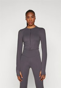 Grå kort, langærmet top med lynlås foran, lavet af glat stof, med tætsiddende design og sømløse manchetter.