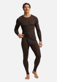 Camiseta térmica de manga larga marrón y leggings a juego, confeccionados en un tejido suave y elástico. Diseño ajustado con escote redondeado y mangas con puños.