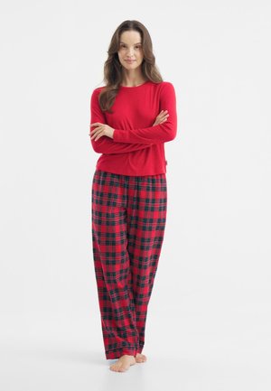 Maglia rossa a maniche lunghe abbinata a pantaloni da pigiama a quadri nei colori rosso, nero e verde. Tessuto morbido con una vestibilità comoda e gamba ampia.