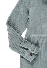 Vestito in corduroy azzurro chiaro con un motivo a righe testurizzato, caratterizzato da un orlo a peplum e maniche con bottoni.