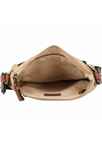 Interior de bolsa de lona beige con cierre de cremallera, acentos de cuero marrón y textura suave. Forrada con una tela suave, con bolsillos mínimos.
