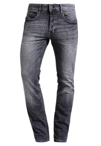 Vaqueros ajustados negros desgastados con cinco bolsillos, cierre de botón y sutiles detalles desgastados en los muslos y las rodillas.