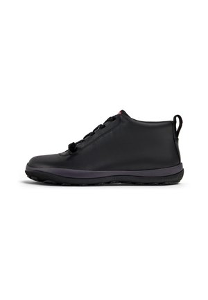 Botas de tobillo de cuero negro con una textura suave, punta redonda, cordones sutiles y una suela de goma flexible en contraste. Incluye una lengüeta para facilitar el calzado.