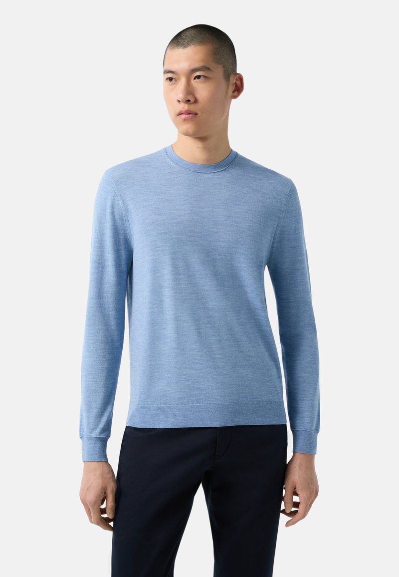 Helles blauer, langärmeliger Pullover aus weichem, strukturiertem Stoff mit Rundhalsausschnitt und gerippten Bündchen, kombiniert mit dunklen Hosen.