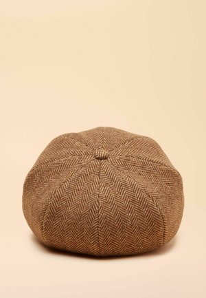 Hnědá kšiltovka se vzorem rybí kosti, zaobleného tvaru, s texturovaným úpletem a středním knoflíkem nahoře, na světlém béžovém pozadí.