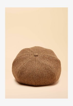 Brun kasket med fiskebenmønster og rund form, med en tekstureret vævning og central topknap, sat mod en lys beige baggrund.