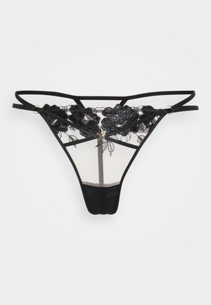 Black lace thong with floral embroidery, sheer mesh panels, adjustable straps, and gold-tone hardware. Soft fabric with minimal coverage.