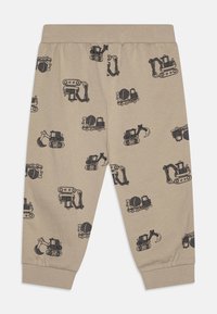 Beige cotton pants with an elastic waist, featuring a black construction vehicle print throughout. Cuffed at the ankles.