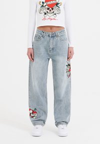 Lysvaskede, højtaljede jeans i en løs pasform, med farverige grafiske tryk af et kranie og et hjerte på hvert ben.