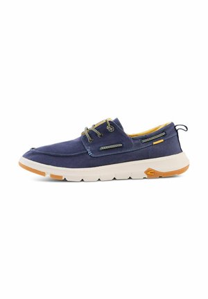 Granatowy, codzienny but typu boat shoe z białą podeszwą, sznurowanym przodem, żółtą wyściółką wnętrza oraz jasnobrązowymi gumowymi akcentami na podeszwie zewnętrznej i pętelce na pięcie.