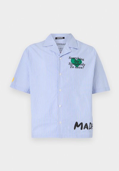 Camicia a maniche corte blu a righe con bottoni frontali. Presenta un testo ricamato verde "Searching For Somebody To Love?" e un dettaglio nero "MADE".