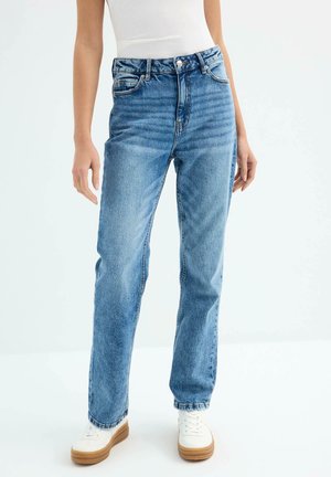 Jeans de mezclilla azul de talle alto con corte recto, que cuentan con cinco bolsillos, trabillas para cinturón y un ligero desgaste en la tela.