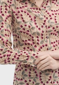 Blomsterprintet skjorte i beige bomuld, med mørk rosa og grå blomstermønstre, med knaplukning og lange ærmer.