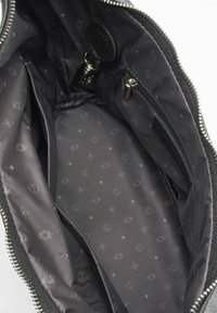 Interno in nylon nero di una borsa con zip argentata. Presenta un motivo sottile di logo e simboli, insieme a una tasca con zip e fodera.