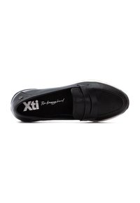 Zapato negro de tipo slip-on con parte superior de cuero liso, que presenta una tira decorativa en la parte frontal y una suela de goma blanca y baja.