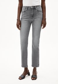 Grå raka jeans med medelhög midja, tillverkade av denim. Har fem fickor och en mjuk, slät yta.