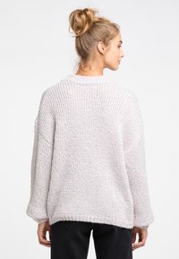 Pulover oversize de tricot fin de culoare gri deschis, cu o textură cu striuri, având un guler larg și umeri căzuți, care se termină la nivelul șoldului.