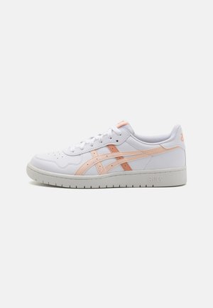 Sneakers bianchi con dettagli rosa, realizzati in pelle liscia, caratterizzati da una punta forata, lacci piatti e una suola in gomma testurizzata.