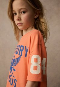 Orange bomull t-shirt med blå tryckt text och ett sprucket vitt nummer "84" på ärmen. Mjuk struktur och avslappnad passform.