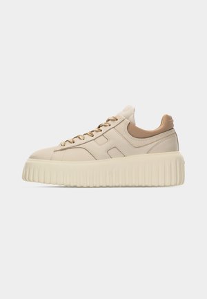 Beige lage sneaker met dikke geribbelde platformzool, bijpassende beige veters en gevoerde kraag, getoond vanaf de rechterkant op een witte achtergrond.