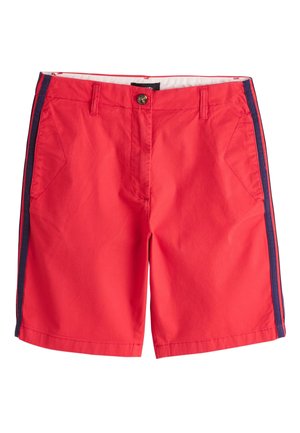 Short rouge longueur genou avec bandes latérales bleu marine, bouton et fermeture éclair à l'avant, passants de ceinture et poches avant inclinées.