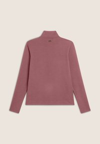 Pull à manches longues, rose, avec un col montant. Tissu doux avec une texture subtile. Petit logo au-dessus du col à l'arrière.