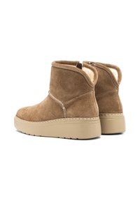 Botas de tobillo de ante marrón con un suave forro en color crema, una suela de plataforma baja y un detalle de costura a lo largo de la parte superior.