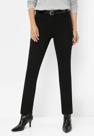 Zwarte rechte denim broek met een riem met een ronde gesp, voorzakken en gedragen met puntige zwarte hakken.