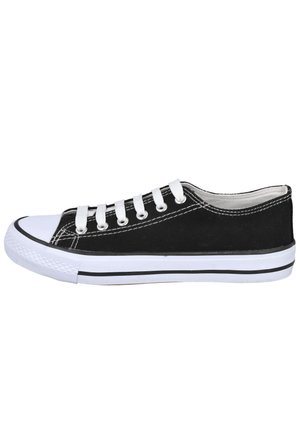 Zapatilla baja de lona negra con puntera de goma blanca, cordones blancos y suela blanca con rayas negras.